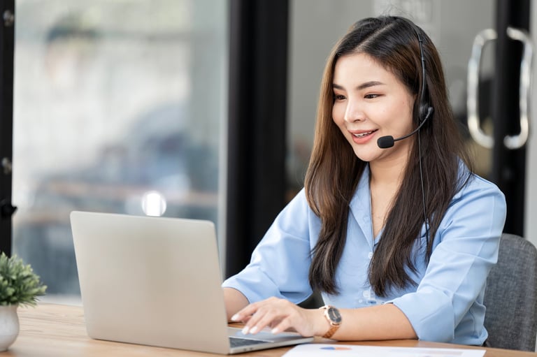 Filipina virtual assistant with headset working from home office