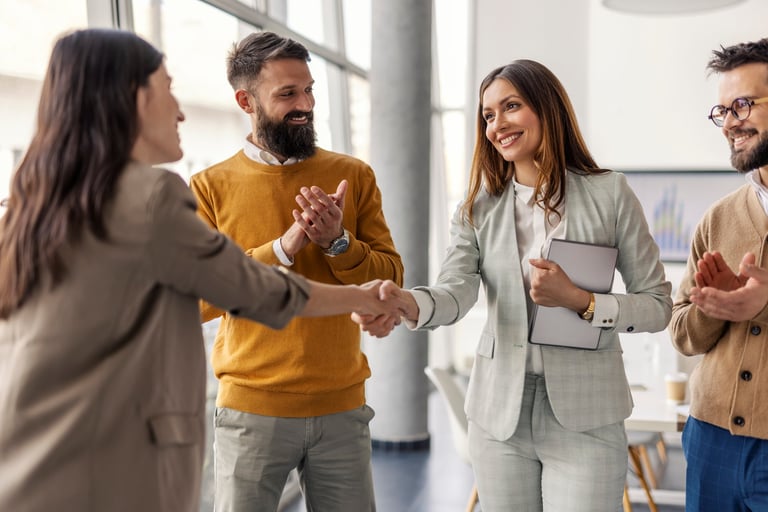 Two successful female executives shaking hands for partnership at office